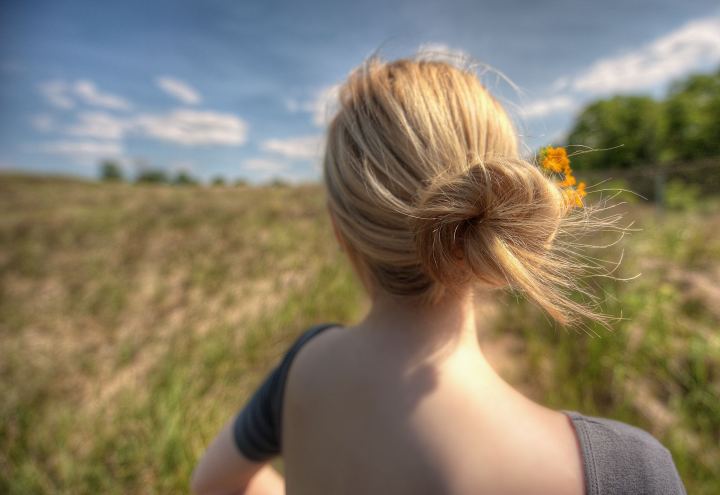 Girl With Flowers In Her Hair In The Field