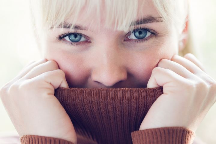 Blonde Girl Hides Her Face In The Collar Sweater