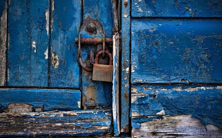 A Rusty Lock On A Wooden Door