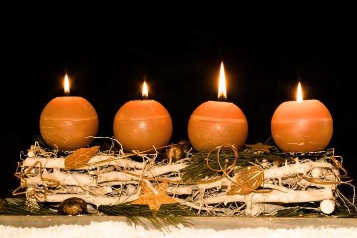 Four Round Burning Candles On A Black Background