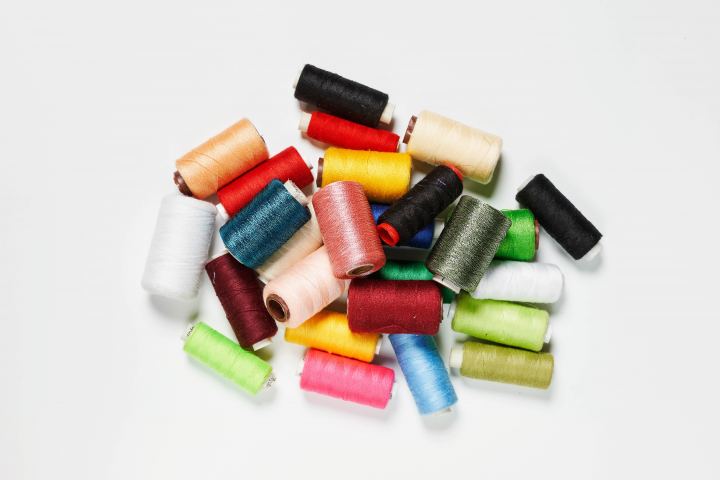 Many Spools Of Multi Colored Thread On A White Background